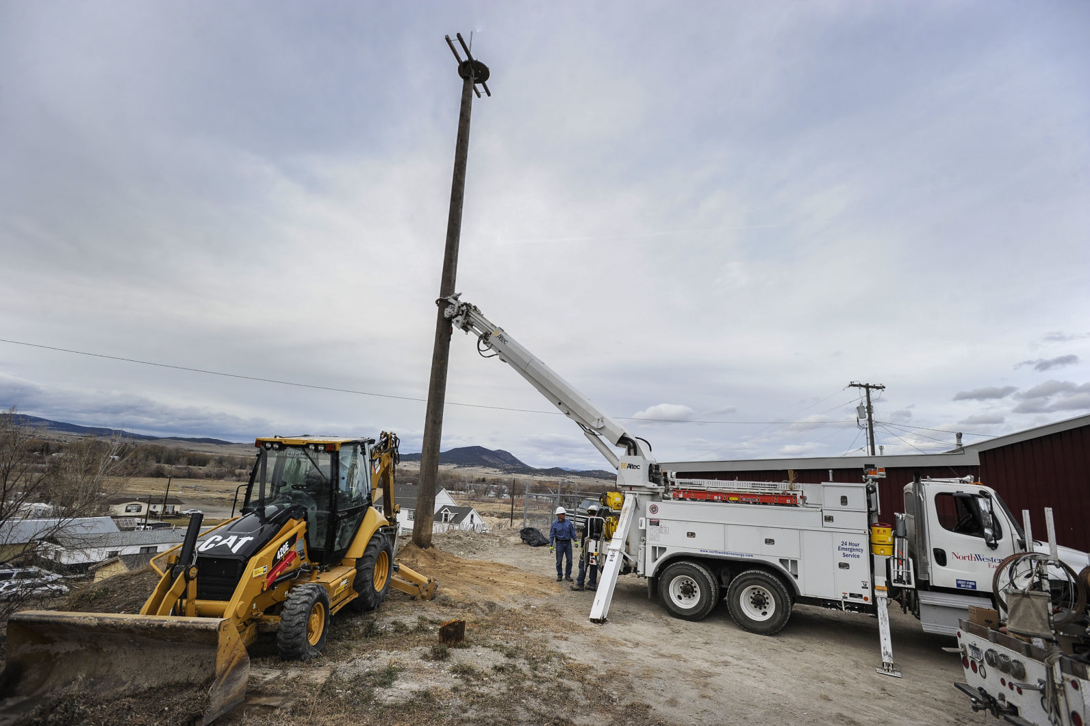 Northwestern Energy linemen install a pole and platform